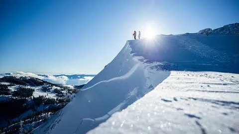 Two skiers stand atop an off-piste area at Alpine.